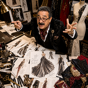 Laurent Gérard en couturier entouré de croquis de mode